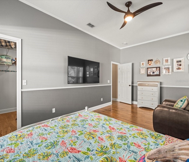 bedroom with a closet, ceiling fan, hardwood / wood-style floors, and ornamental molding