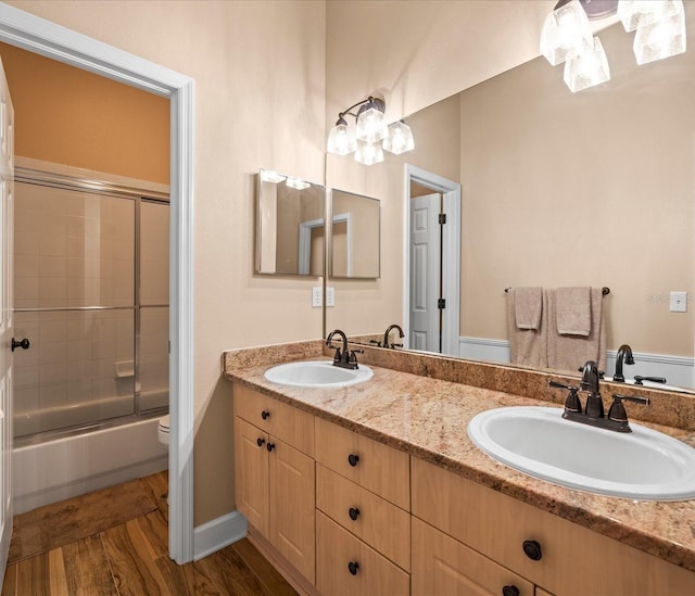 full bathroom featuring wood-type flooring, vanity, toilet, and enclosed tub / shower combo