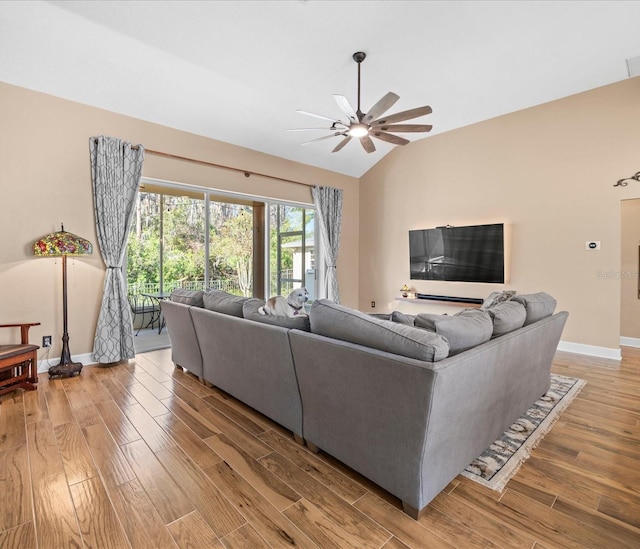 living room featuring hardwood / wood-style floors, vaulted ceiling, and ceiling fan