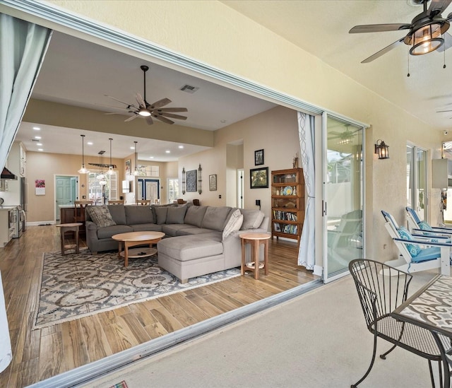 living room featuring ceiling fan and hardwood / wood-style floors