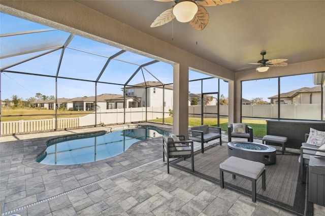 view of swimming pool featuring ceiling fan, a lanai, a patio, and an outdoor living space with a fire pit