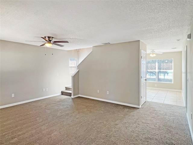 unfurnished living room featuring carpet flooring, a textured ceiling, and ceiling fan