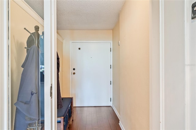 doorway with a textured ceiling and dark hardwood / wood-style flooring