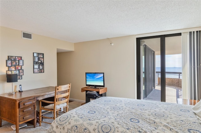 carpeted bedroom with a textured ceiling and access to outside