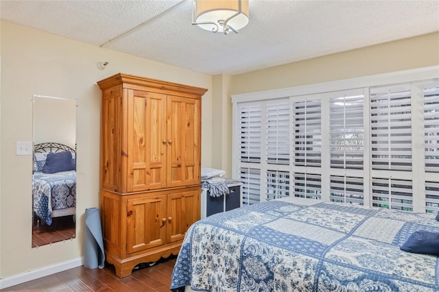 bedroom featuring a textured ceiling and dark hardwood / wood-style flooring