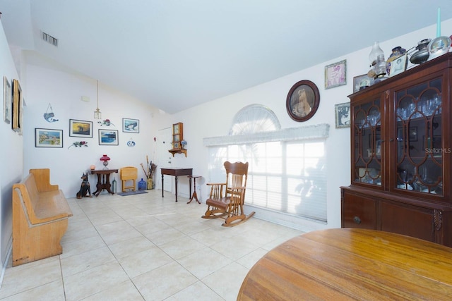 living area featuring vaulted ceiling and light tile patterned floors