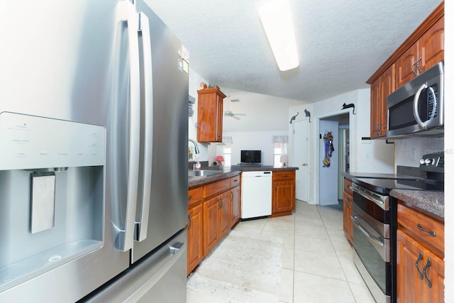 kitchen with sink, light tile patterned flooring, a textured ceiling, and appliances with stainless steel finishes