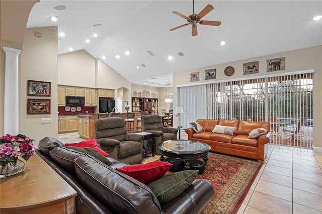 living room featuring ceiling fan, high vaulted ceiling, arched walkways, light tile patterned flooring, and ornate columns