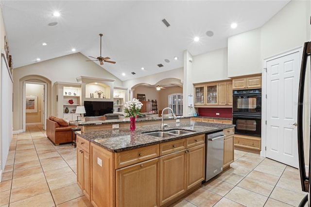 kitchen with arched walkways, dishwasher, dobule oven black, and a sink