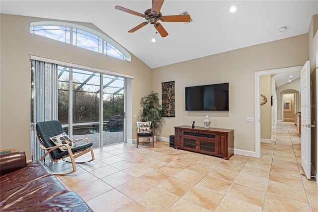 sitting room featuring a ceiling fan, arched walkways, a sunroom, and light tile patterned floors