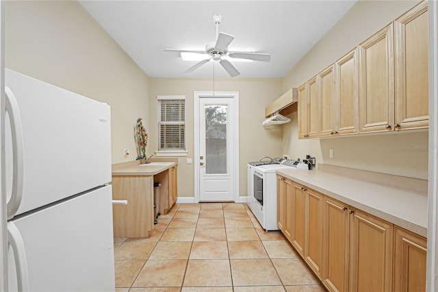 kitchen with light brown cabinetry, light countertops, freestanding refrigerator, light tile patterned flooring, and a ceiling fan