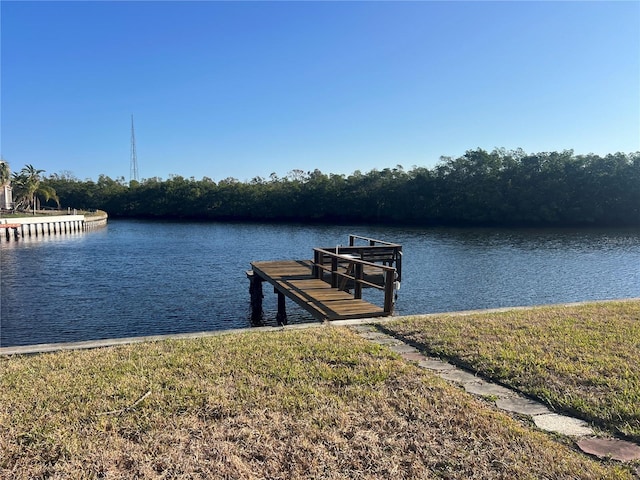 view of dock with a water view and a lawn