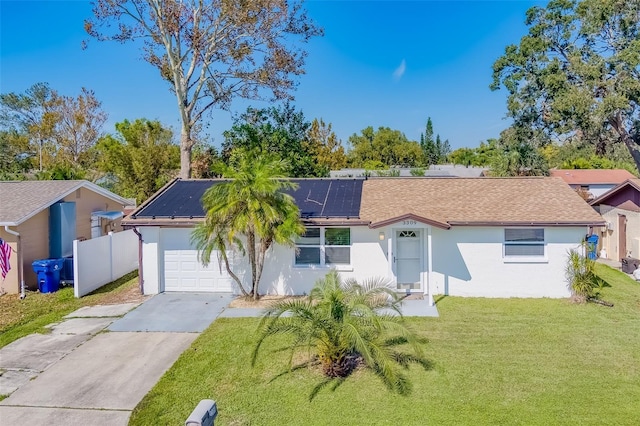 ranch-style house featuring a front yard and solar panels