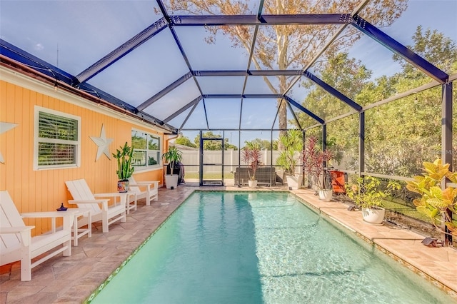 view of pool featuring glass enclosure and a patio area