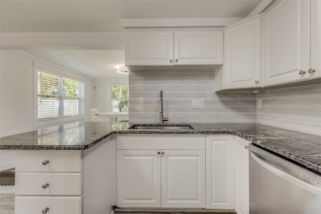 kitchen featuring white cabinets, stainless steel dishwasher, dark stone counters, and sink