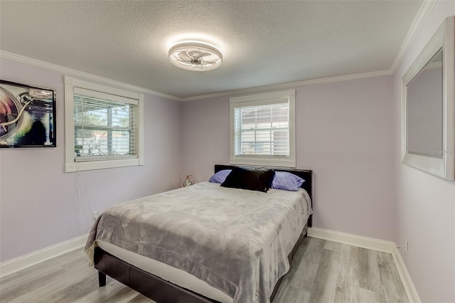 bedroom with a textured ceiling, light wood-type flooring, and crown molding