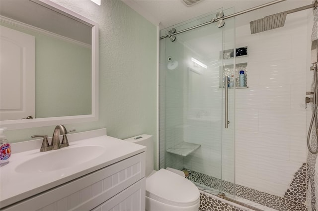 bathroom with vanity, toilet, a shower with shower door, and crown molding