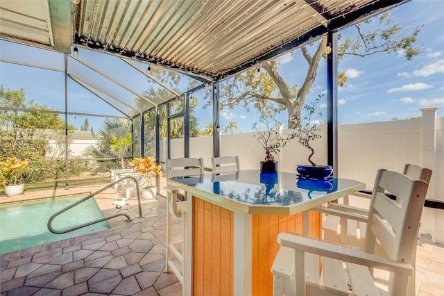 view of patio featuring a lanai and an outdoor bar