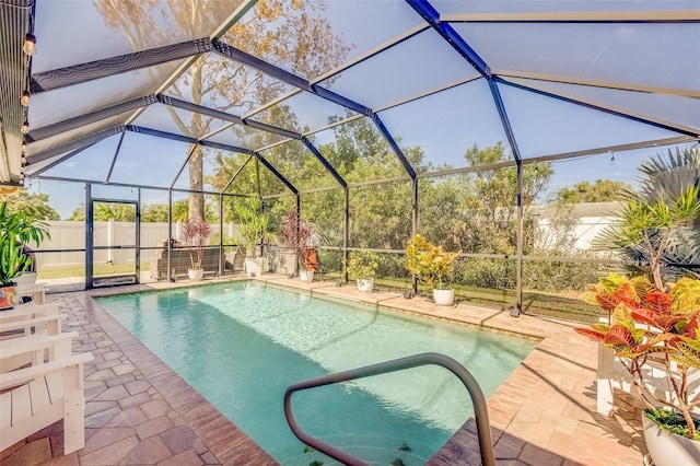 view of pool with glass enclosure and a patio area