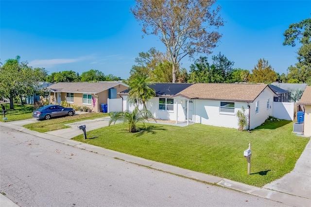 ranch-style house featuring central air condition unit and a front yard