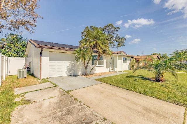 ranch-style house featuring cooling unit, a garage, and a front yard