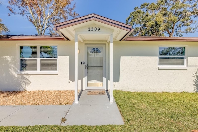 doorway to property with a yard