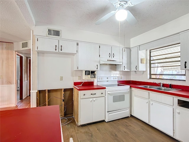 kitchen featuring a textured ceiling, sink, electric range, white cabinets, and hardwood / wood-style floors