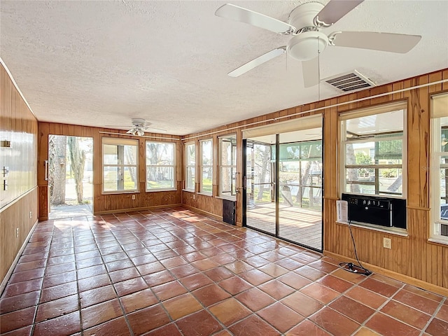 unfurnished sunroom featuring ceiling fan