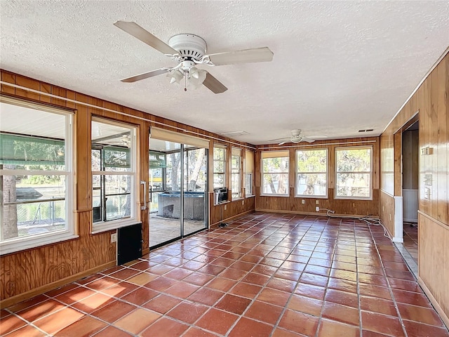 unfurnished sunroom featuring a wealth of natural light, cooling unit, and ceiling fan