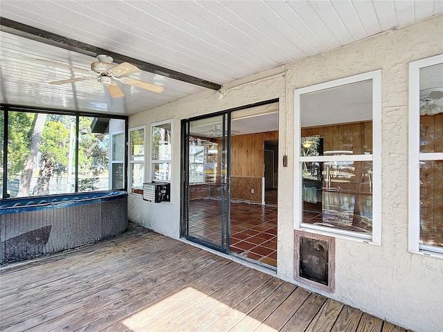 unfurnished sunroom featuring ceiling fan and beam ceiling