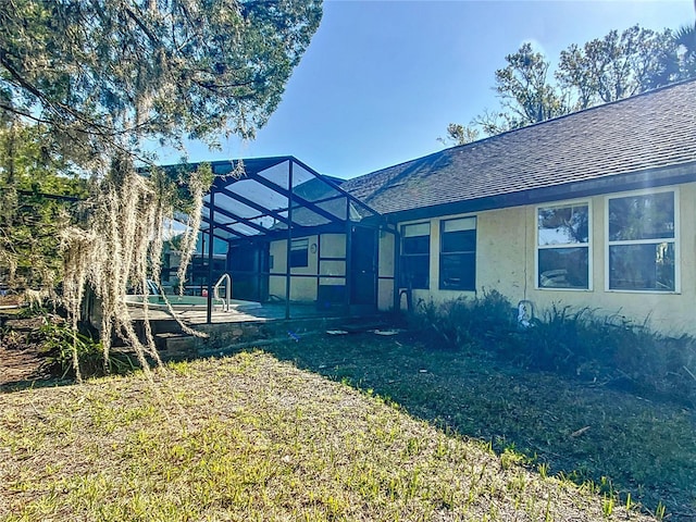 back of property with a patio, a lanai, and a lawn