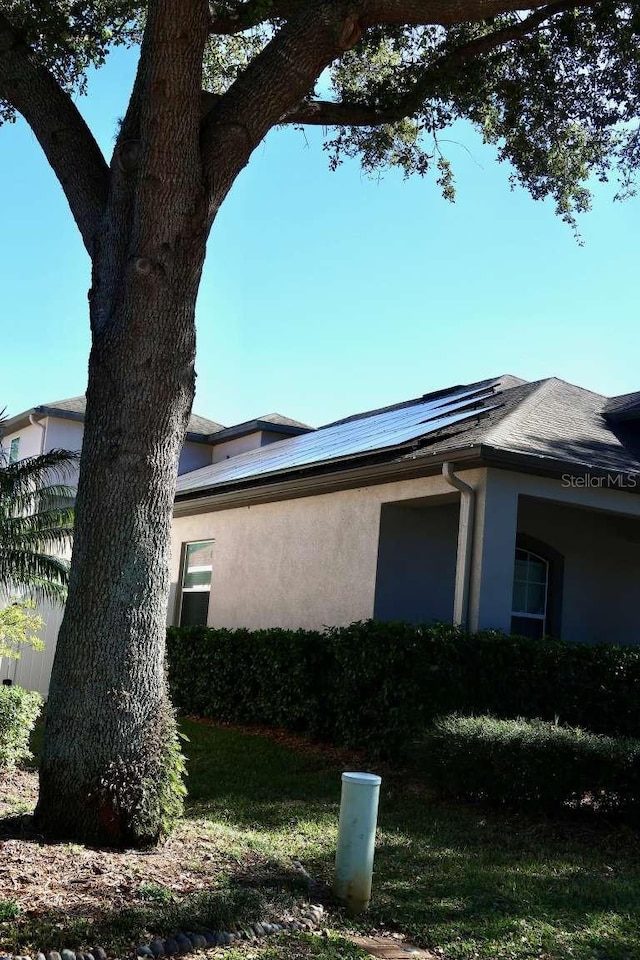 view of side of home with solar panels