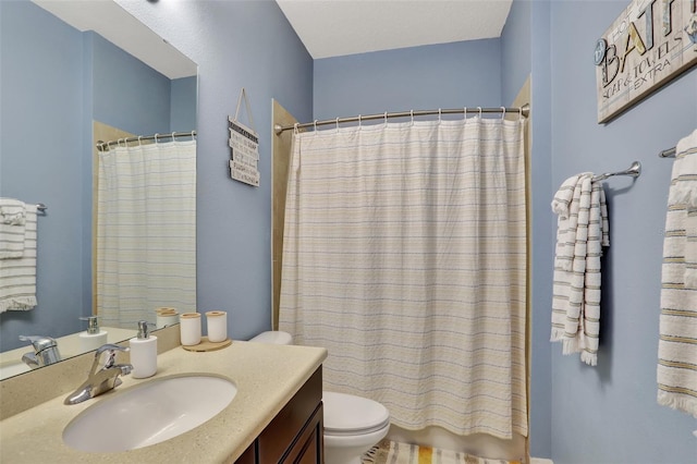 bathroom with toilet, vanity, and a shower with curtain