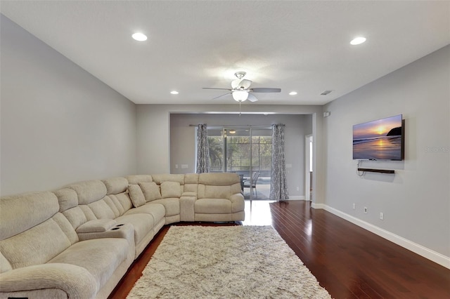 living room with ceiling fan and dark wood-type flooring