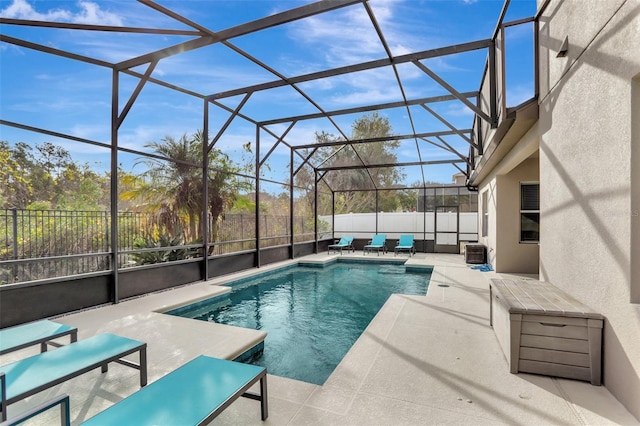 view of swimming pool featuring glass enclosure and a patio area