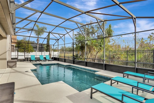 view of pool with a patio area and glass enclosure