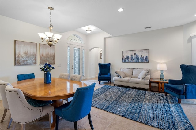 tiled dining space featuring an inviting chandelier