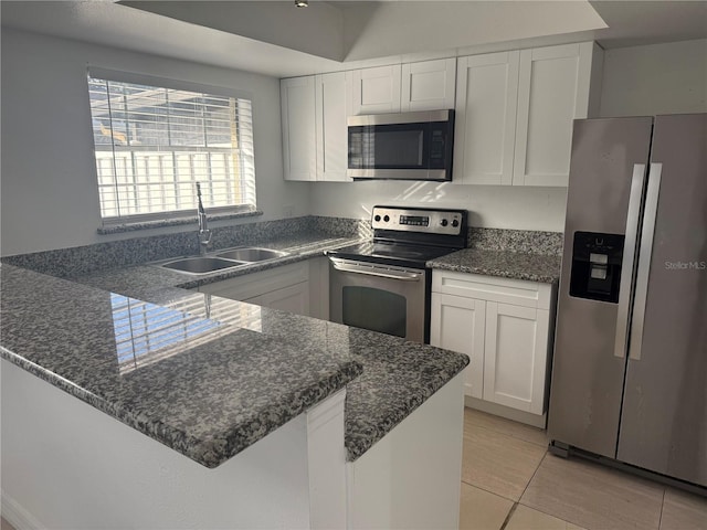 kitchen with sink, light tile patterned floors, appliances with stainless steel finishes, white cabinetry, and kitchen peninsula