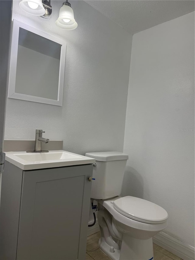 bathroom with vanity, a textured ceiling, and toilet