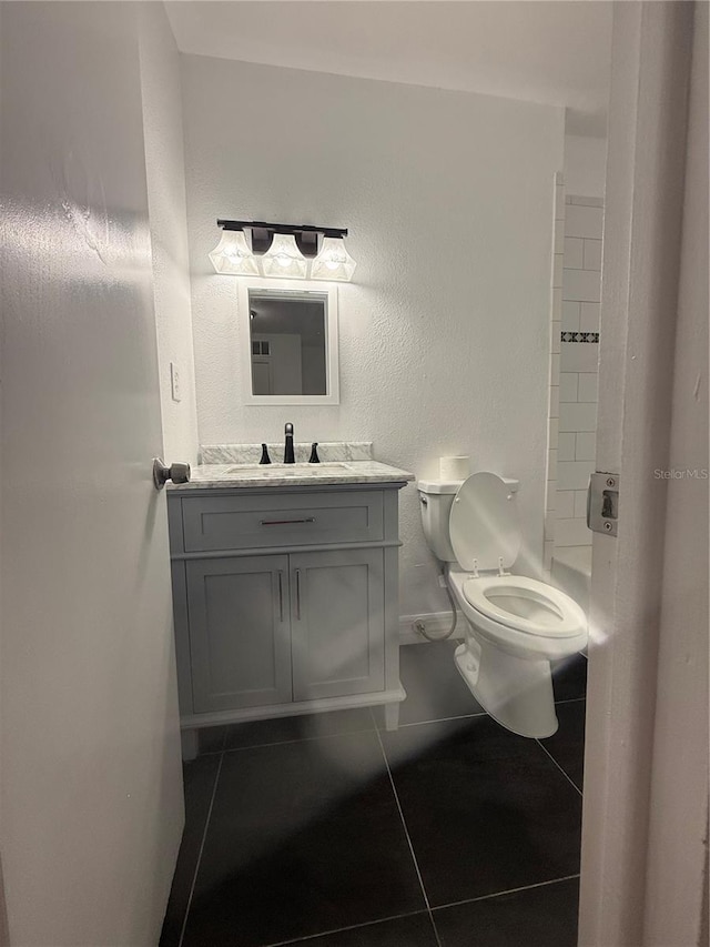 bathroom featuring tile patterned flooring, vanity, and toilet