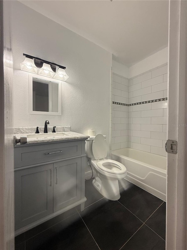 full bathroom with tile patterned flooring, vanity, toilet, and tiled shower / bath