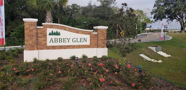 community / neighborhood sign with a yard