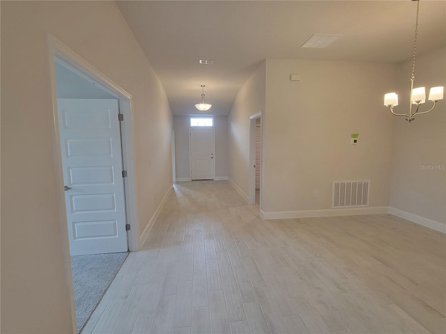 entrance foyer featuring light wood-type flooring and an inviting chandelier