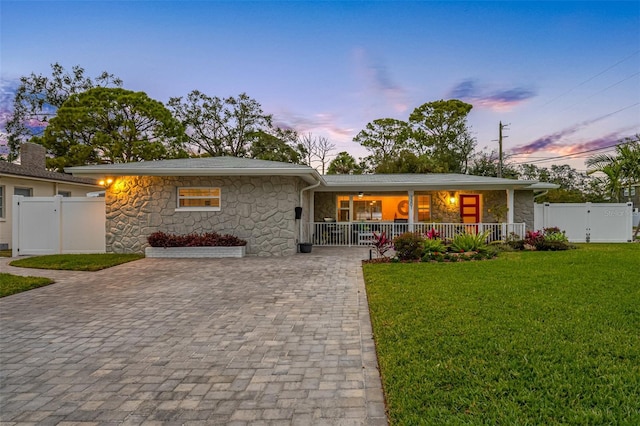 view of front of house with a lawn and a porch