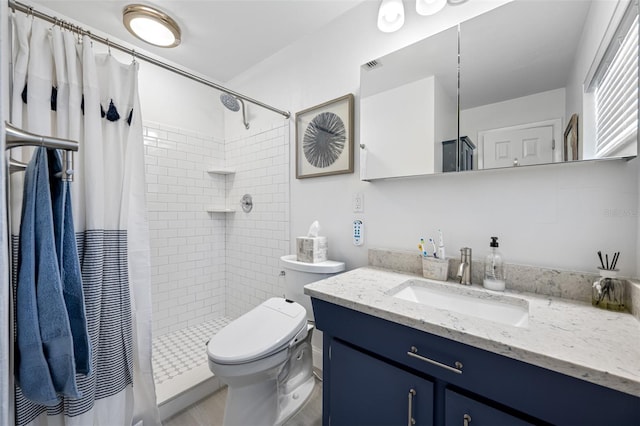 bathroom featuring toilet, vanity, and a shower with curtain