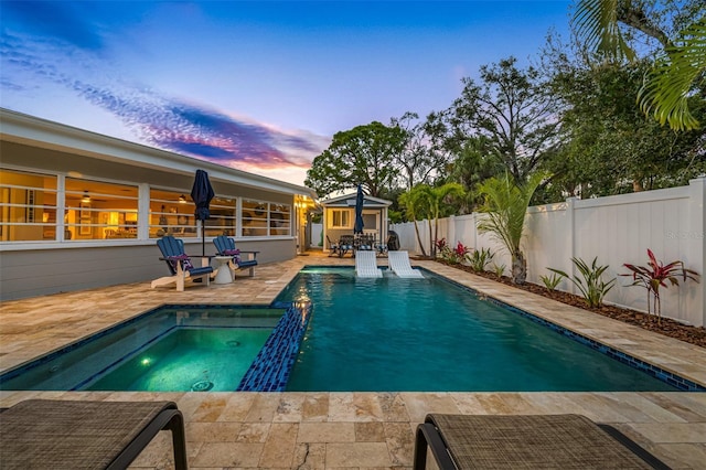 pool at dusk featuring a patio area