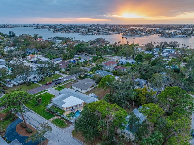 aerial view at dusk featuring a water view