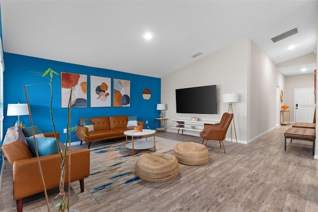 living room featuring lofted ceiling and hardwood / wood-style floors