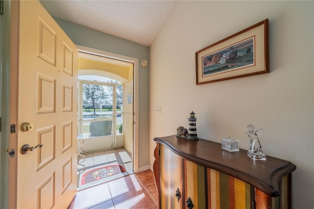 entrance foyer with a textured ceiling and light tile patterned flooring