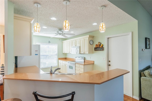 kitchen featuring pendant lighting, a sink, a textured ceiling, white appliances, and a peninsula